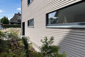 A modern building with horizontal siding and large windows. - Holiday home with 4 bedrooms (Timmendorfer Strand)