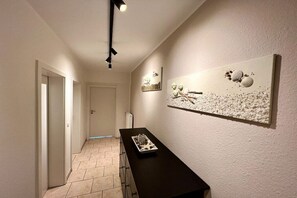 A hallway with a black reception desk, a door, and wall art. - Holiday apartment in Dahme with swimming pool (Dahme)