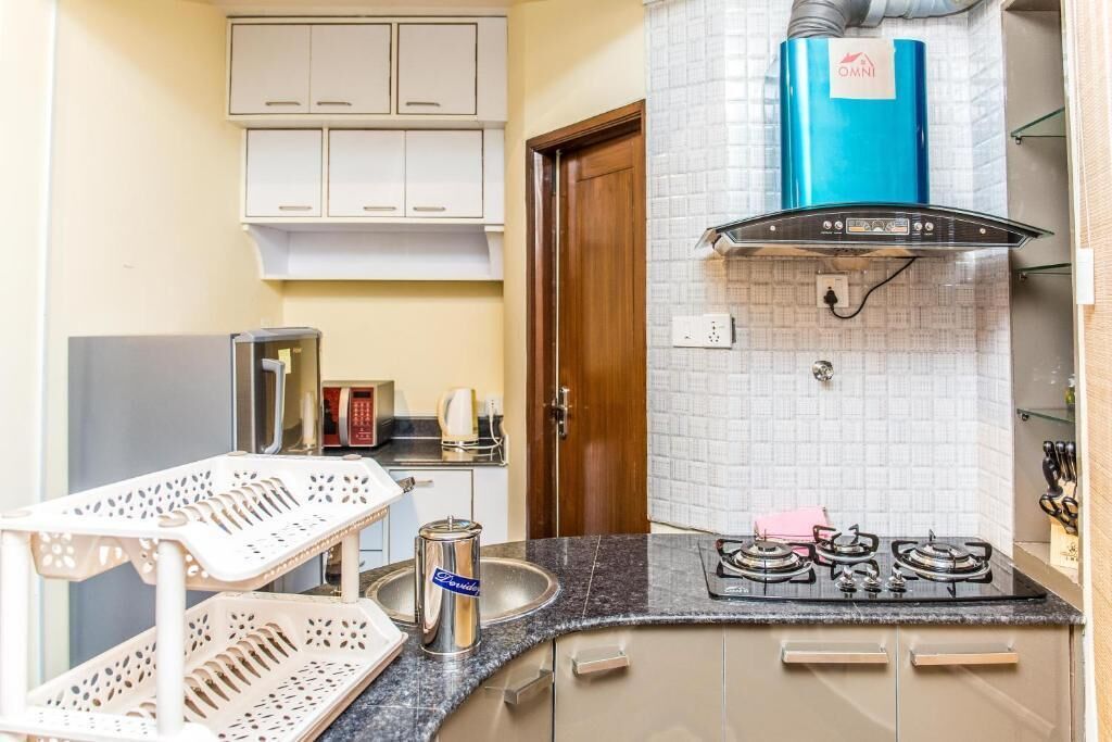 A kitchen with a gas stove, a coffee maker, and a cabinet above the sink.