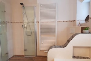 A bathroom with a glass-enclosed shower, a white towel rack, and a tiled shower area. - Villa in the woods - Eagle's nest (Roßhaupten)