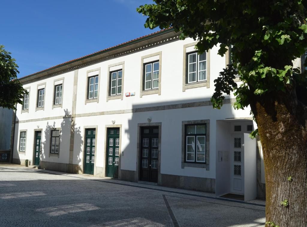 Un edificio con fachada simétrica, múltiples ventanas y puertas.