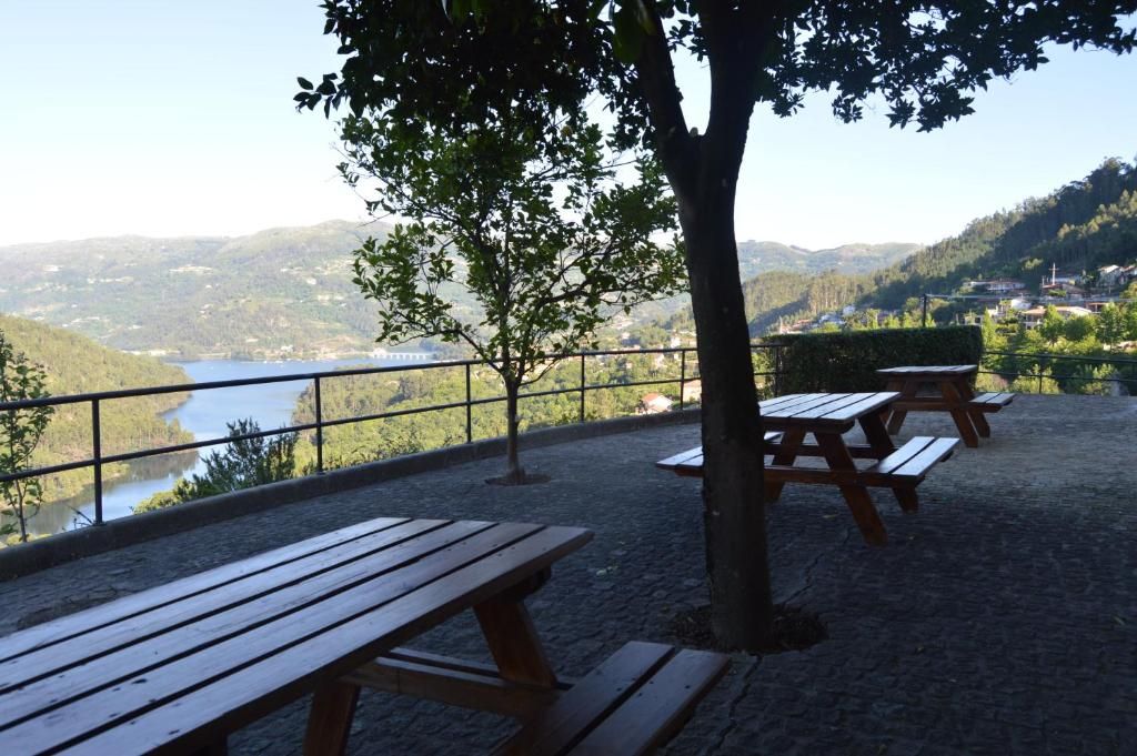 Un espacio para picnic con bancos y vistas a un lago y colinas.