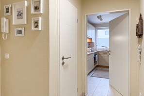 A hallway with a door leading to a kitchen area. - Holiday apartment with 1 bedroom (Timmendorfer Strand)