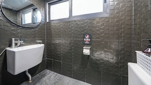 A bathroom with a white sink, a mirror, a window, and a wall with a geometric pattern. - Ddlanchae Hanok Stay - Main House (JEONJU)