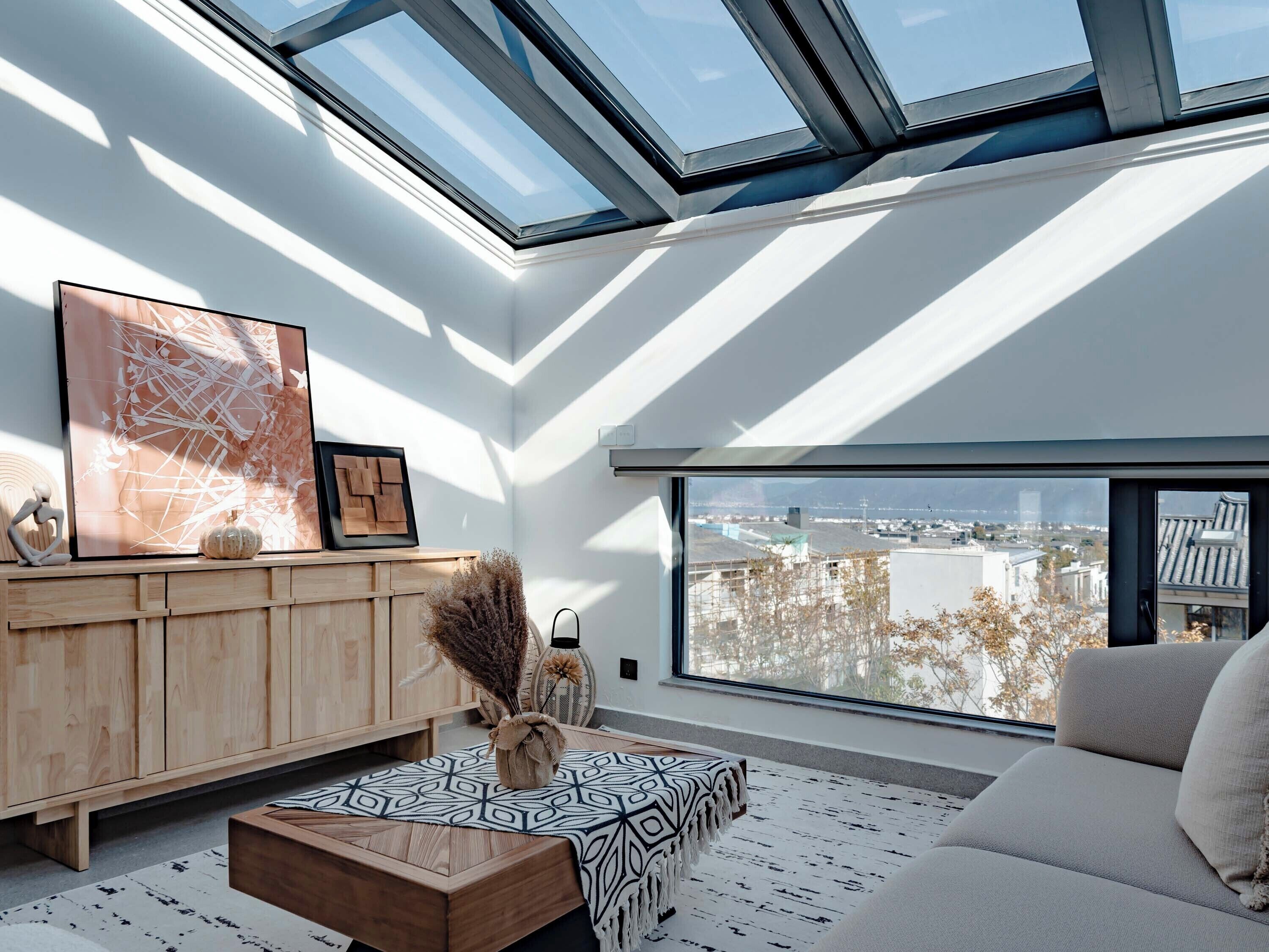 A modern living room with a skylight, a large window, and a city view.