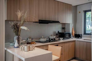 Una cocina moderna con armarios de madera, una isla central con asientos, un microondas y una estufa.