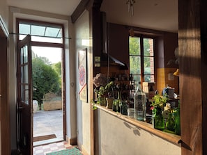 Eine Küche mit einer Holzauslage, einem Fenster und einer Tür, die in einen Garten führt.