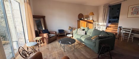 Amplia sala de estar con sofá, sillón y una mesa de comedor.