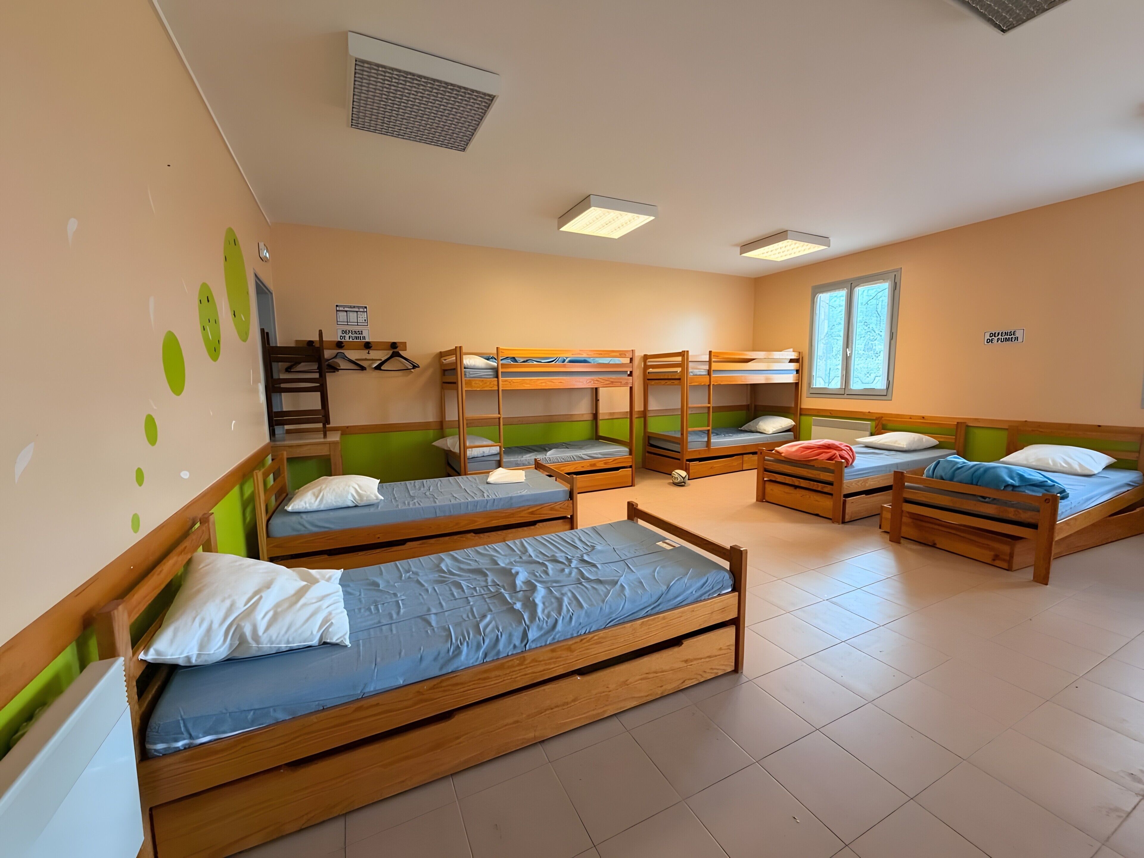 Une chambre de dortoir avec des lits superposés, un bureau et une chaise.
