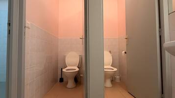 Un baño con dos inodoros, un lavabo y un espejo.
