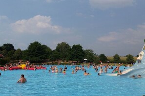Ein großer Außenpool mit mehreren Bahnen und einer Wasserrutsche.