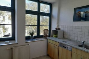 A kitchen with a window, a radiator, and a sink. - Marina at the sailing harbor (Karlshagen)