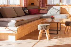 A cozy room with a wooden sofa, a small table, and a stool.