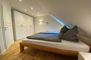 Une chambre à coucher avec un lit, une armoire et une lucarne.