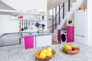 A modern kitchen with granite countertops, a dishwasher, a microwave, and a washing machine. - Calahonda Beach III – Beachfront Apartment with Sea Views in Mijas Costa (Mijas Costa)