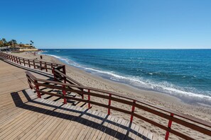 A wooden boardwalk leading to a sandy beach with a clear blue sky. - Calahonda Beach III – Beachfront Apartment with Sea Views in Mijas Costa (Mijas Costa)