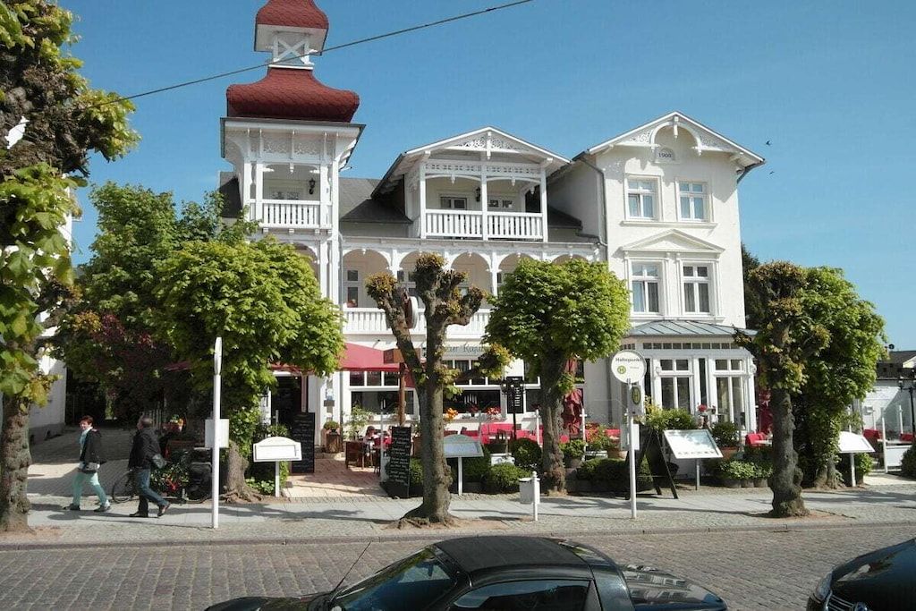 A historic building with a red dome, white facade, and multiple balconies.