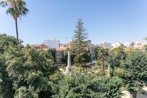 Un paysage urbain avec des bâtiments, un ciel dégagé et une variété d’arbres.