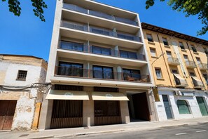 Un immeuble à plusieurs étages doté de balcons, d’une entrée au niveau du sol et d’une devanture visible.