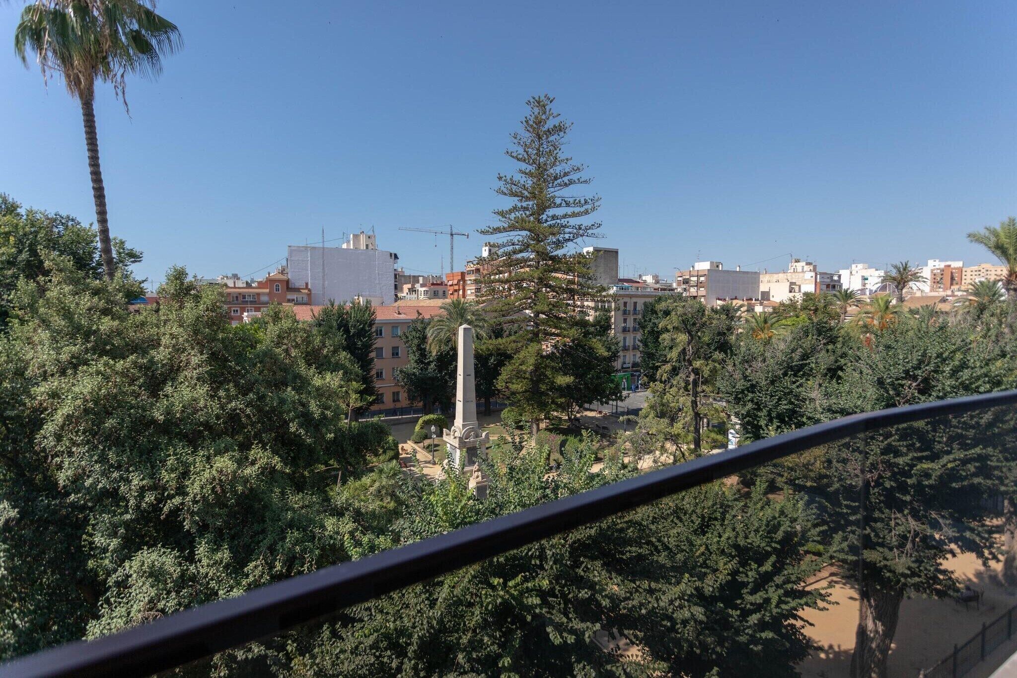 A residential area with buildings, trees, and a clear sky.