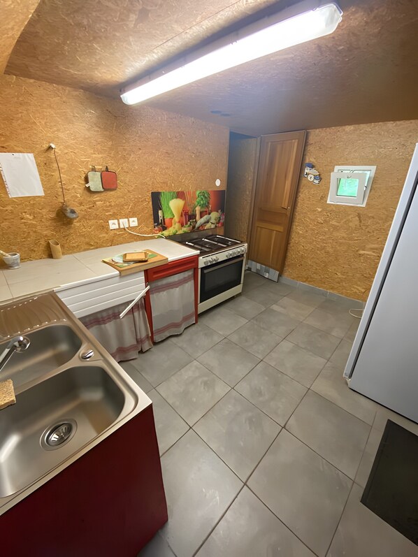 A kitchen with a sink, stove, and refrigerator.