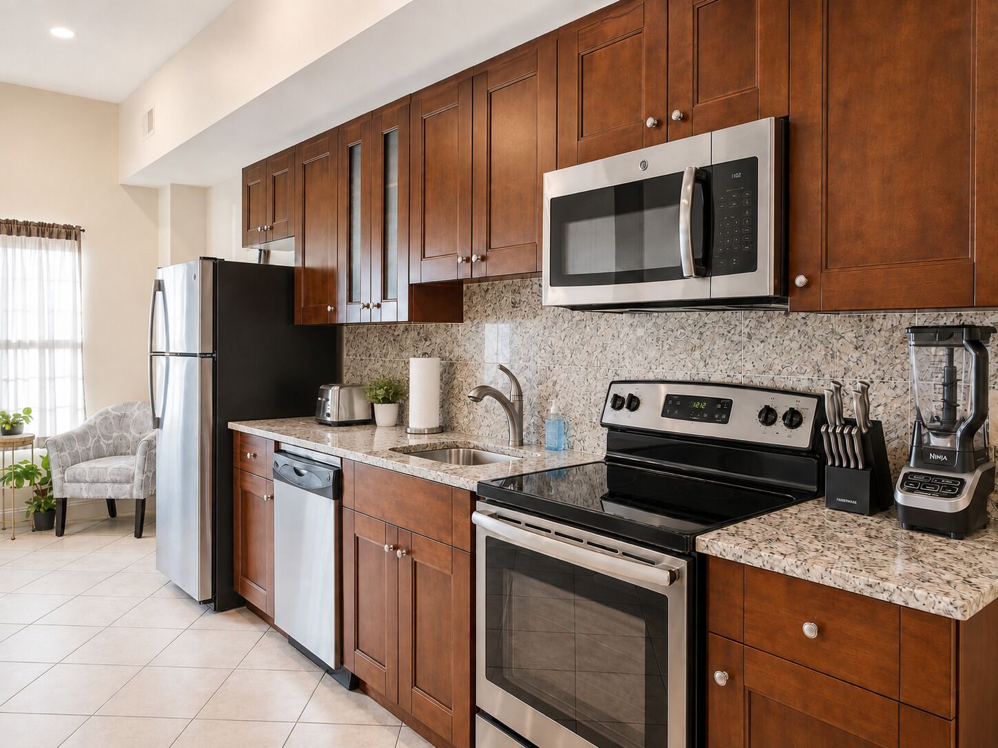 A modern kitchen with wooden cabinets, stainless steel appliances, a granite countertop, and a dishwasher.