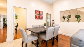 A dining area with a rectangular table, six chairs, and a tiled floor.