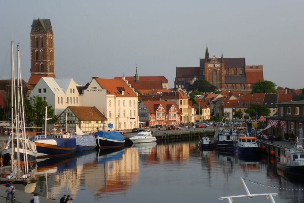 A harbor with boats, a hotel, and historic buildings.