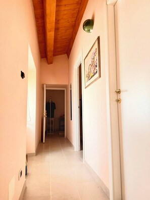 A hallway with a wooden ceiling, a door with a handle, and a framed picture on the wall. - BREAD AND TULIPS - a cozy vacation home with a view of Rocca Calascio (Castelvecchio Calvisio)