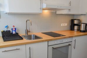 A modern kitchen with a stainless steel sink, a coffee maker, and a dishwasher. - Holiday apartment with 2 bedrooms (Lübeck)