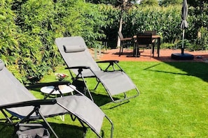 A garden with two reclining chairs and a small table. - Apartment in Otterndorf with swimming pool (Otterndorf)
