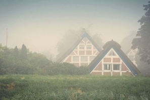 A house with a steeply pitched roof and a symmetrical facade, surrounded by greenery. - 2 Hein Garrn Fruit Farm (Mittelnkirchen)