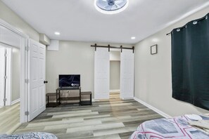 A bedroom with a bed, a TV, a desk, and a wardrobe. - 6Br Spacious•HolidayFAMILYHOME (Williamsport)