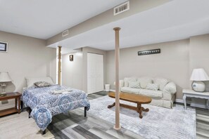 A bedroom with a bed, a sofa, a coffee table, and a lamp. - 6Br Spacious•HolidayFAMILYHOME (Williamsport)