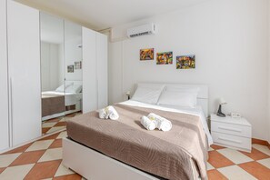 A hotel room with a bed, a bedside table, a lamp, a mirror, and artwork on the wall. - Zip House Apartment Verona (Verona)