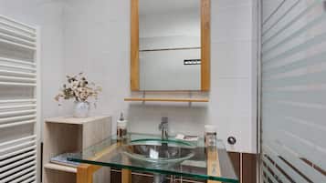 Une salle de bain avec un lavabo en verre, un meuble-lavabo en bois et un miroir.