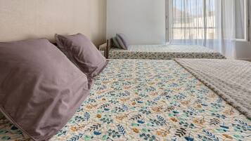 Een kamer met twee bedden, elk met een bloemenprint dekbed.