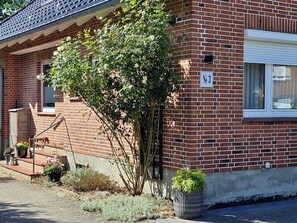 A brick building with a window, a door, and a sign indicating 'No 3'.