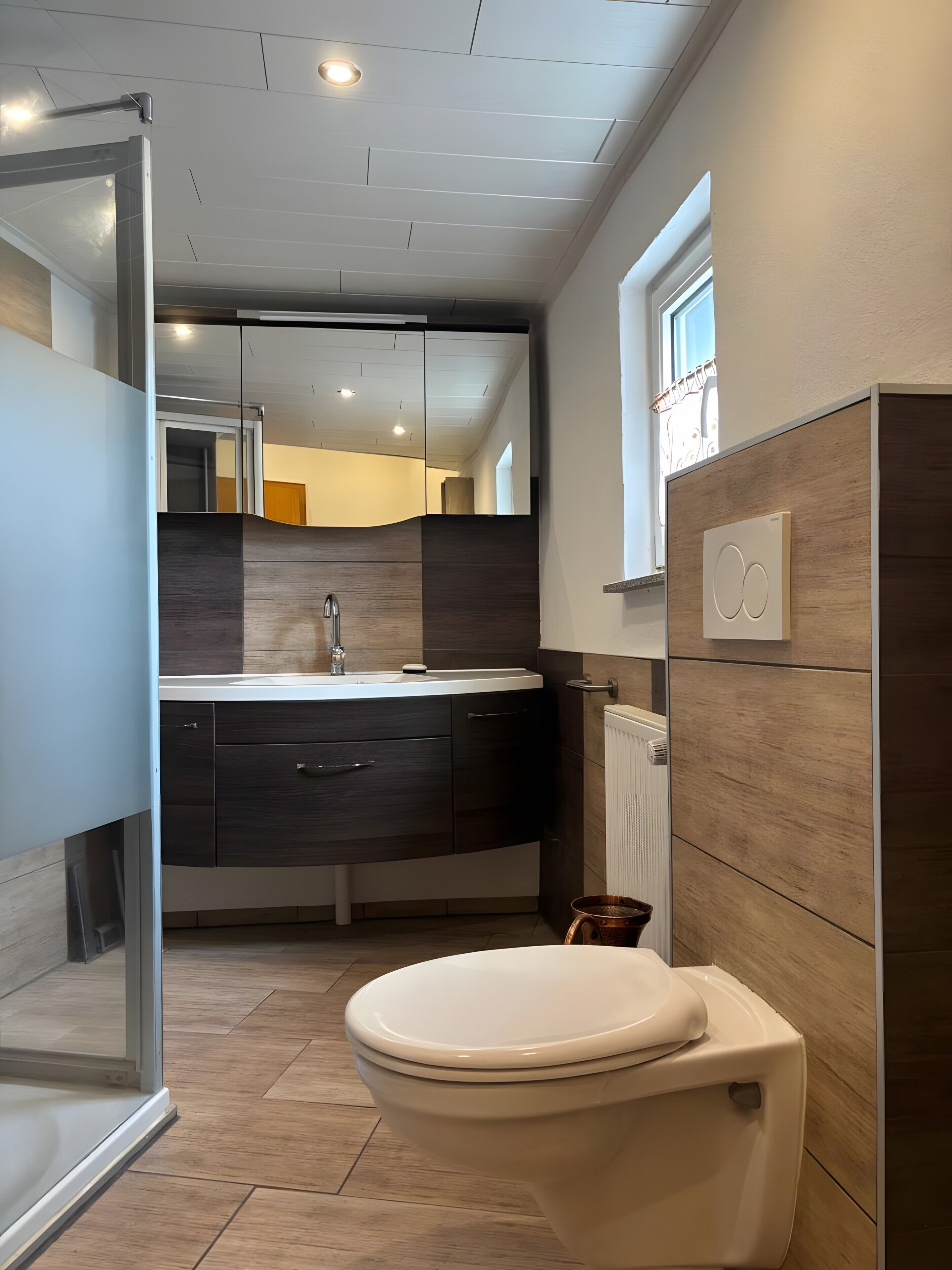 Une salle de bain moderne équipée de toilettes, d’un lavabo et d’un miroir.