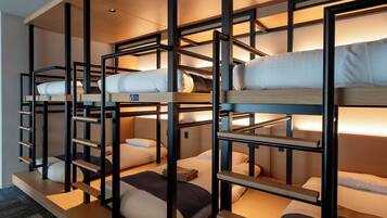 A bunk bed room with multiple levels, wooden railings, and a carpeted floor.