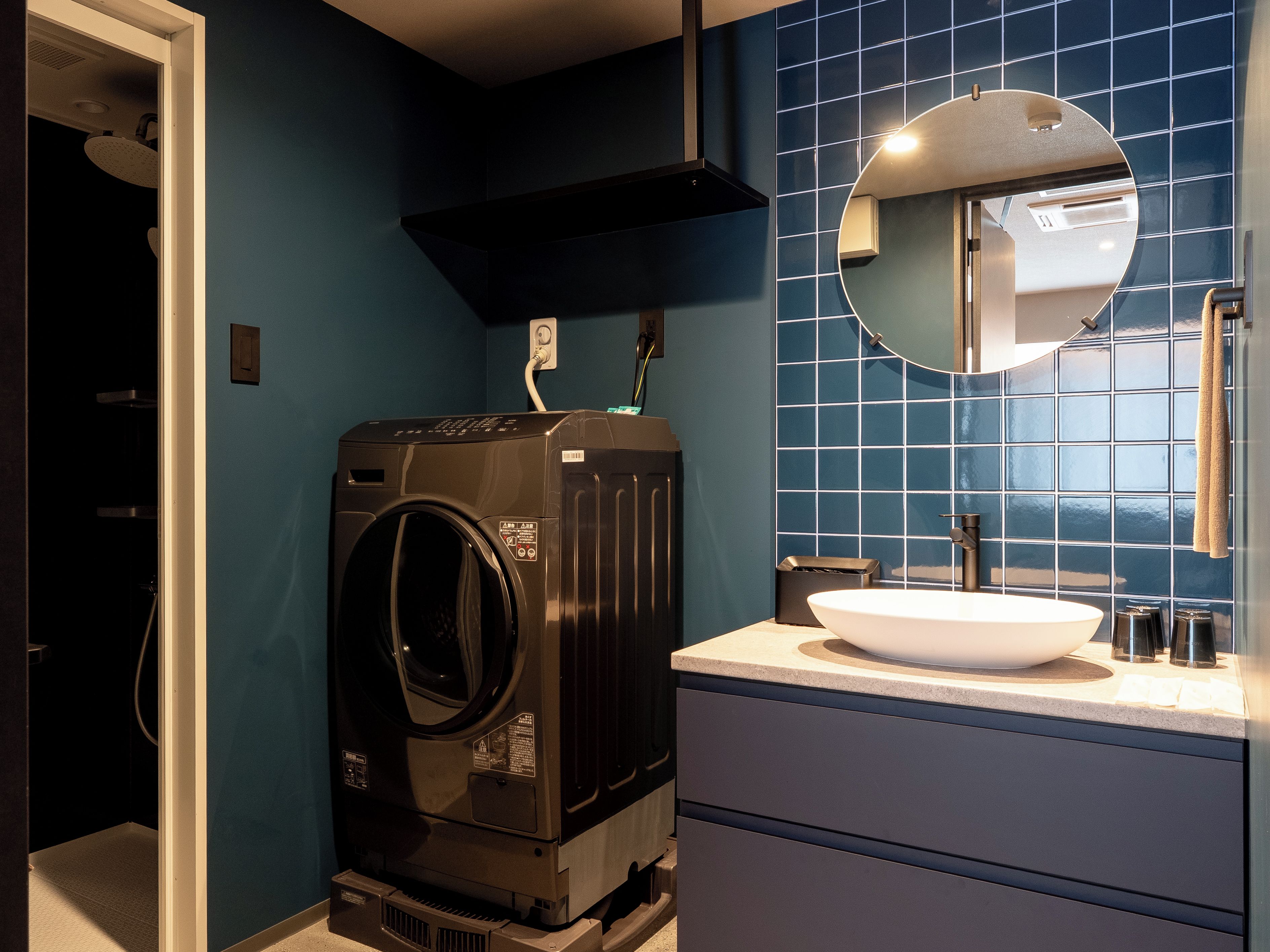 Un baño pequeño con lavadora incorporada, un lavabo y un espejo.