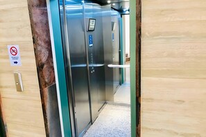 An elevator interior with a metallic finish, a control panel, and a no bicycle sign on the wall. - Vacation Apartment 'Cozy  Playa Las Americas' with Sea View, Balcony and Wi-Fi (Costa Adeje)