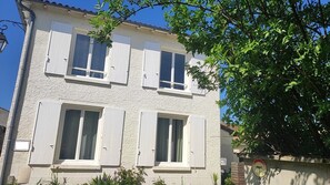En tvåvåningsbyggnad med vita ytterväggar och fönsterluckor, en väl synlig dörr och en liten skylt med texten ”PRIVAT” som visar att det är privat egendom.
