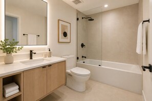 Ein modernes Badezimmer mit Waschbecken, Toilette und Badewanne.