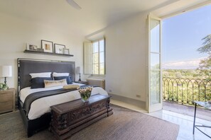 A bedroom with a large bed, bedside tables, a dresser, and a view of the outdoors. - Refined And Luxurious Villa In the Outskirts Of Lucca (Lucca)