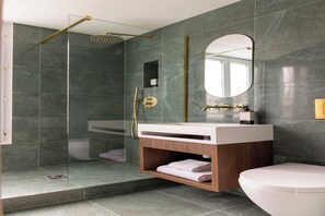 Een moderne badkamer met een douchecabine van glas, een wit wastafelmeubel met een houten kast en een grote spiegel.