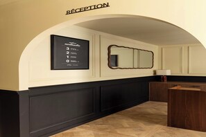 A reception area with a framed sign indicating room numbers and a reception desk.