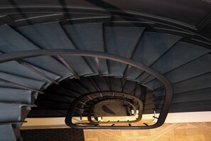 Un escalier en colimaçon avec une rampe en métal.