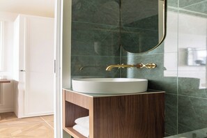 Een moderne badkamer met een wit wastafel, houten wastafelmeubel en een grote spiegel.