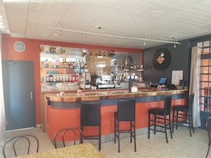 A bar area with a counter, chairs, and a coffee machine. - La Diligence HOTEL (Le Brignon)